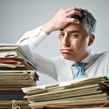 Ondernemer achter stapels papierwerk